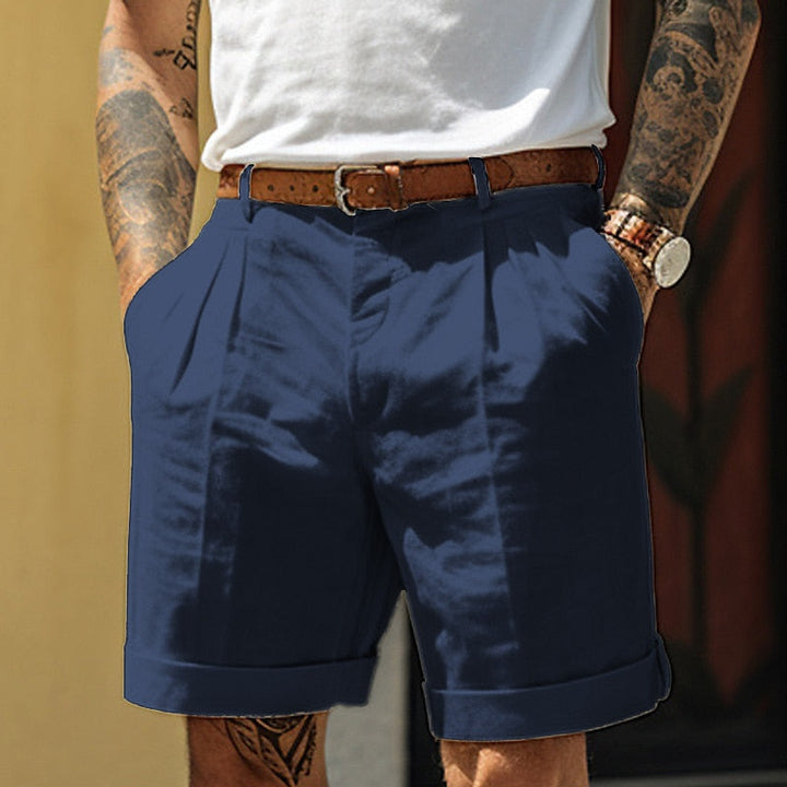 Navy blue men's pleated tailored shorts with belt, rolled cuffs and relaxed fit pockets