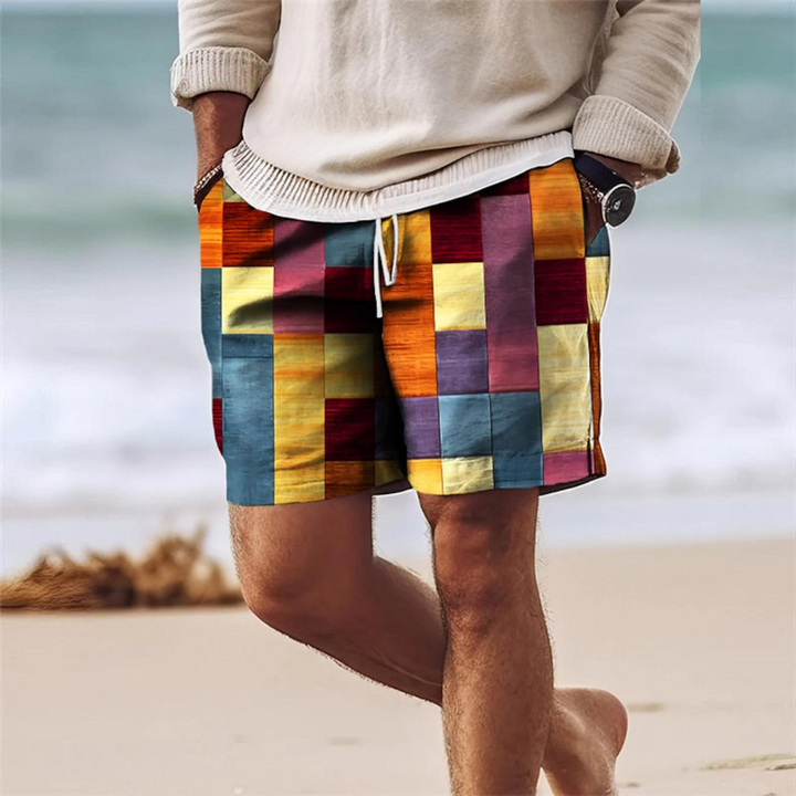 Men's summer printed board shorts with pockets, warm multicolor patchwork blocks on beach