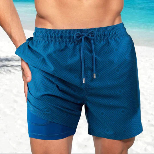 Dark teal geometric men's swim shorts with matching drawstring and blue built-in liner shorts