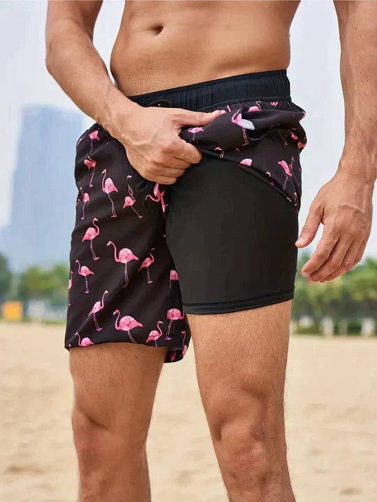 Black flamingo print swim shorts for men showing built-in black liner and elastic waistband