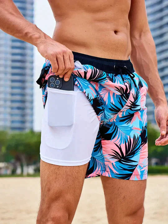 Blue and pink tropical print men's swim shorts with white liner and phone pocket