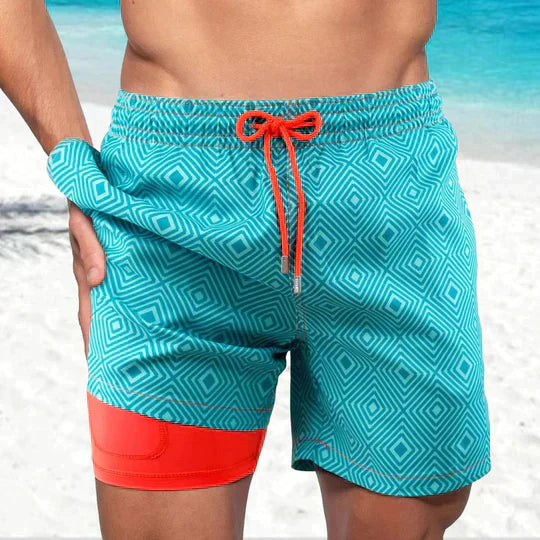 Teal geometric print men's swim shorts with orange drawstring and red lined shorts