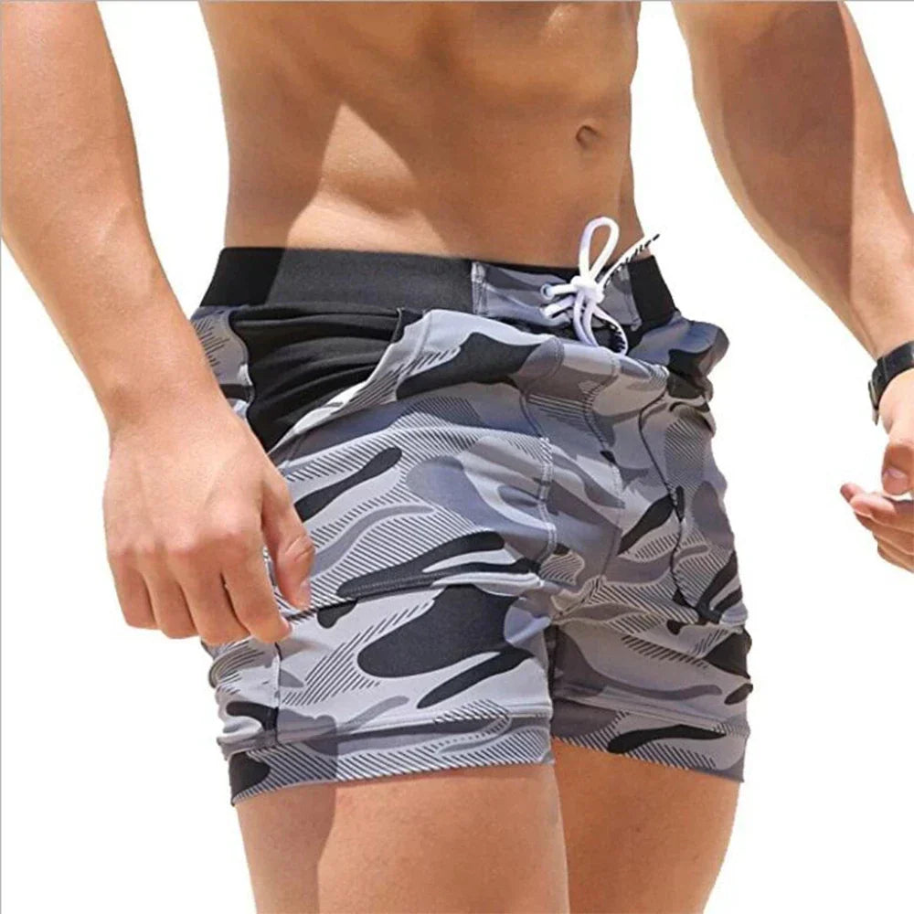 Side view of gray printed men's swimsuit shorts with pocket detail, black waistband and drawcord
