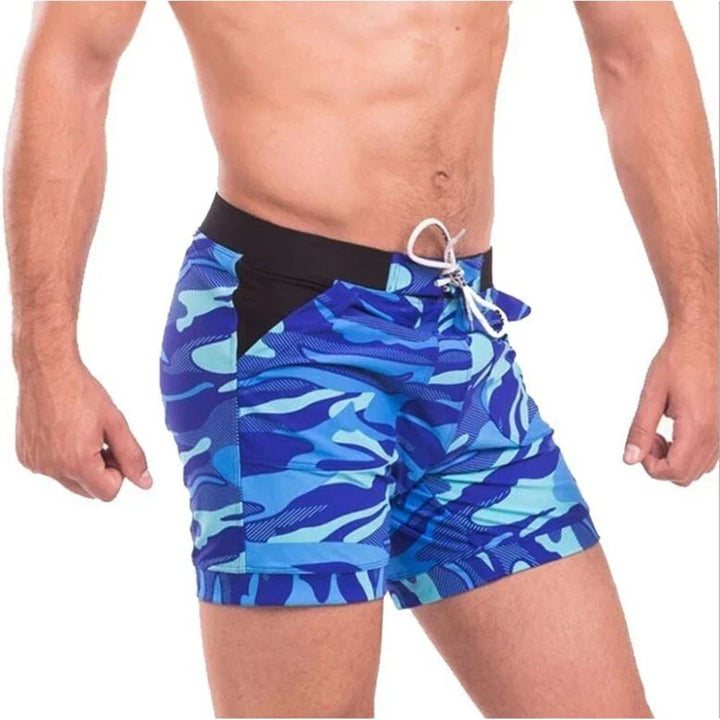 Angled side view of blue printed men's swim shorts showing fit and black waistband with drawstring