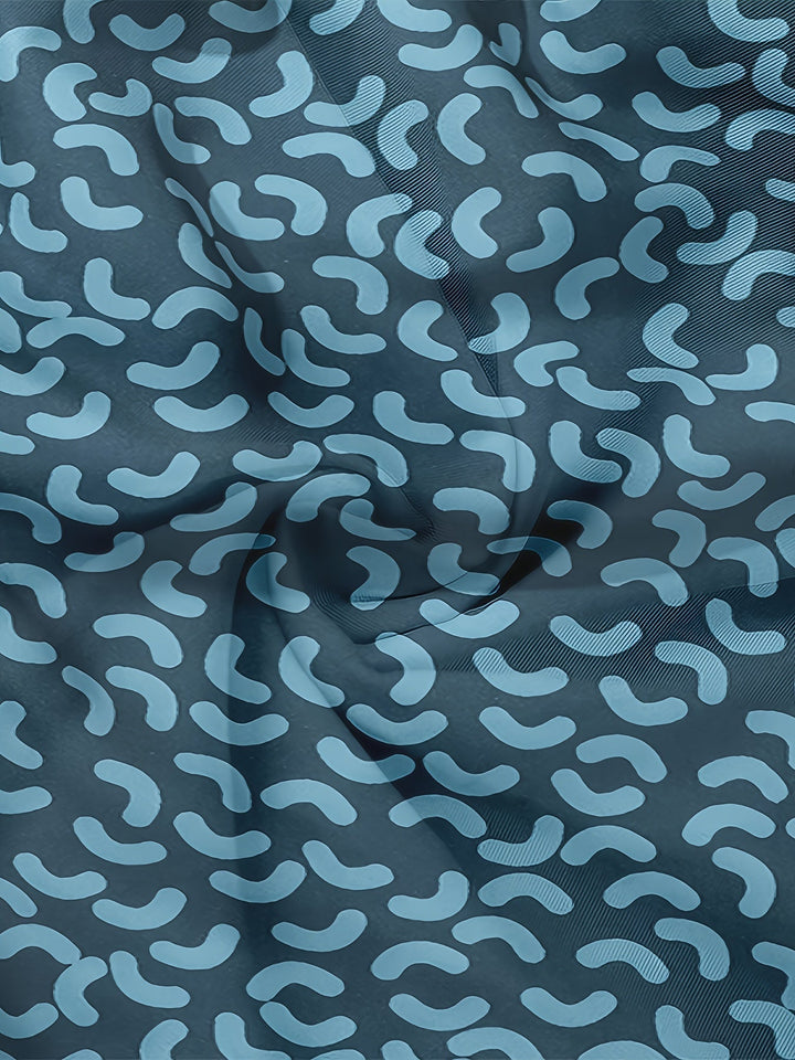 Macro detail of blue swim shorts fabric showing elastic waistband stitching and print texture