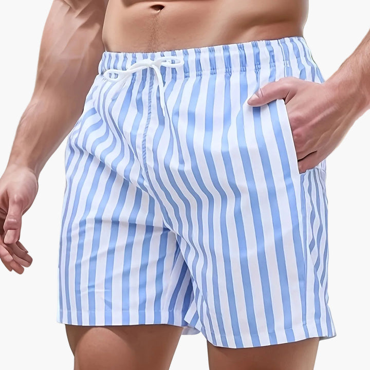 Close-up of men's striped swim shorts with drawstring waist and relaxed fit