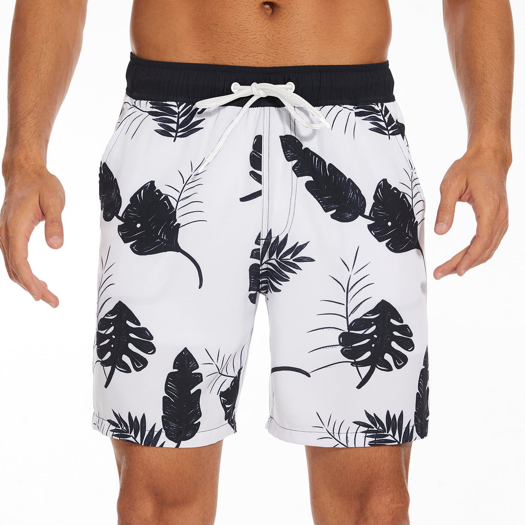 White men's swim shorts with black tropical leaf print and drawstring waist