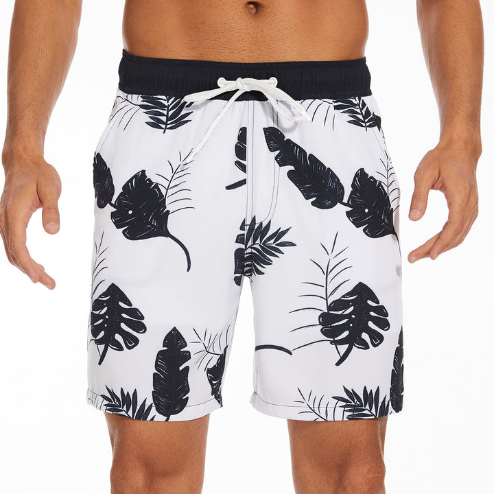 White men's swim shorts with black tropical leaf print and drawstring waist