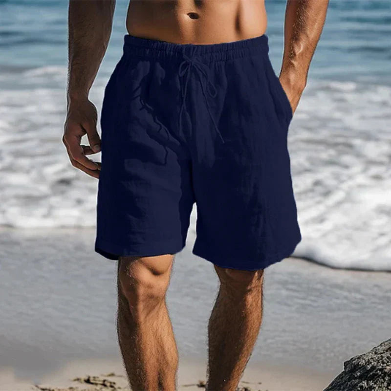 Navy blue men's swim shorts with pockets and elastic waistband at the beach