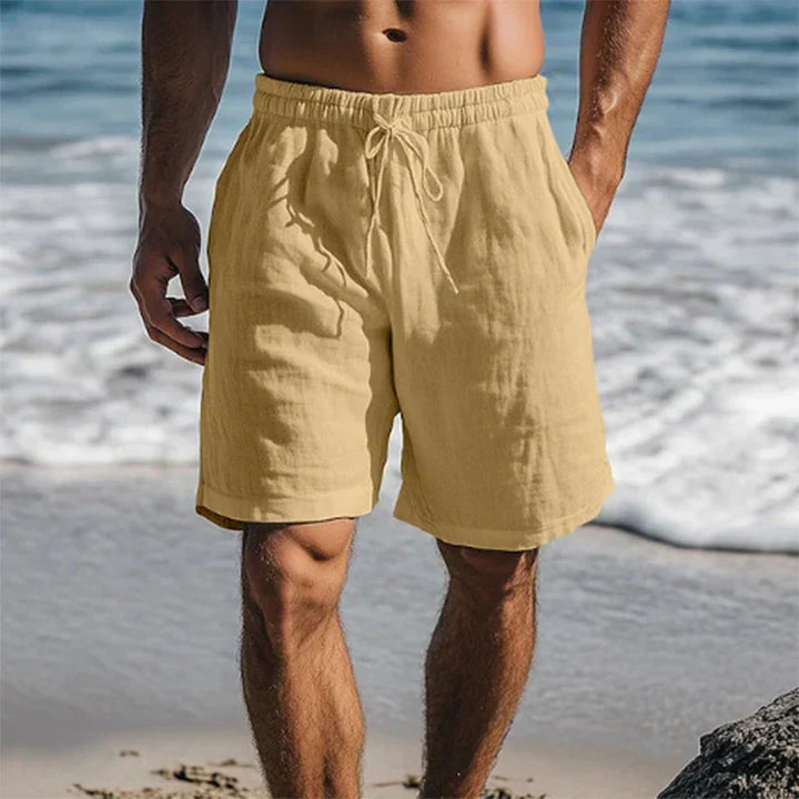 Tan men's swim shorts with pockets, drawstring waist, and casual beach style