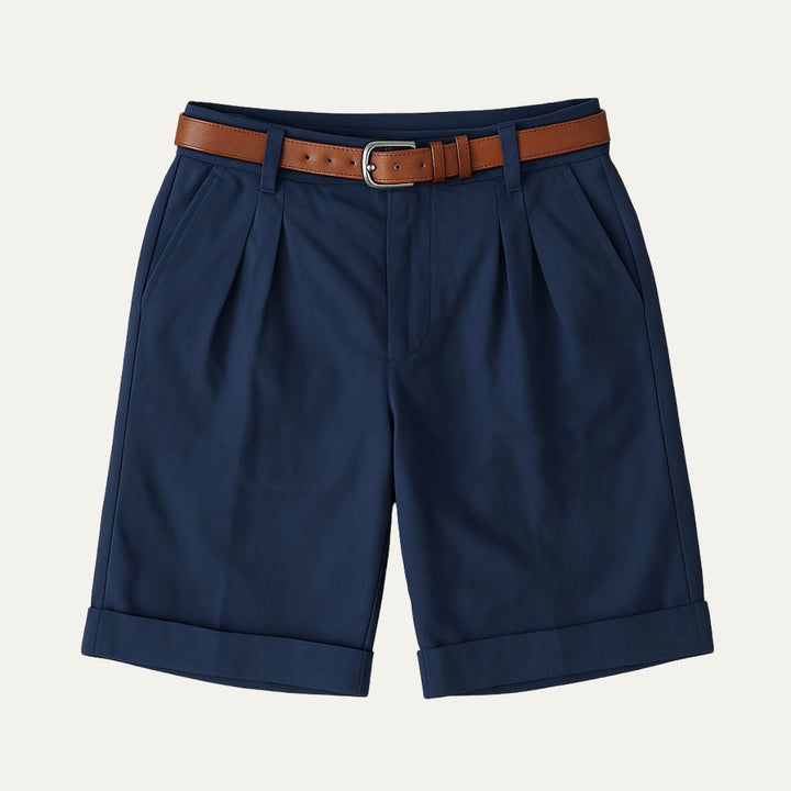 Navy tailored linen shorts with pleats, cuffed hems, and brown belt