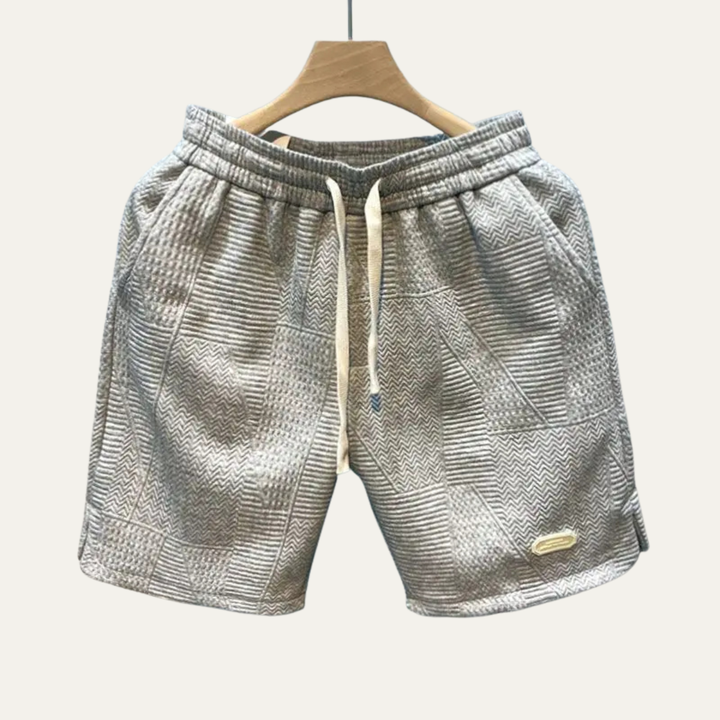 Gray textured men's summer shorts on hanger with drawstring waist and patch details