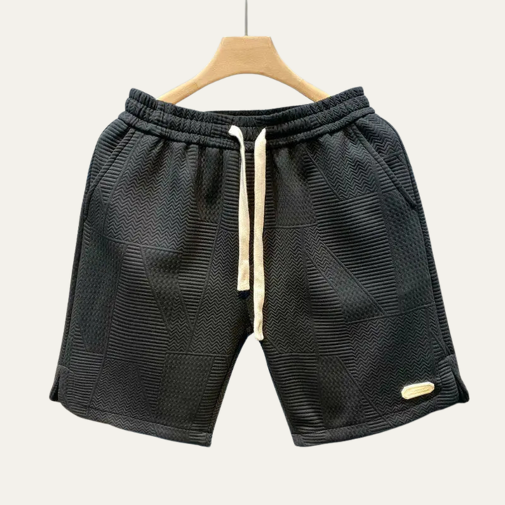 Black textured men's shorts with drawstring waist, patchwork design, and casual fit
