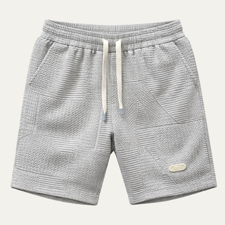 Light gray textured drawstring shorts with patchwork pattern and side pockets
