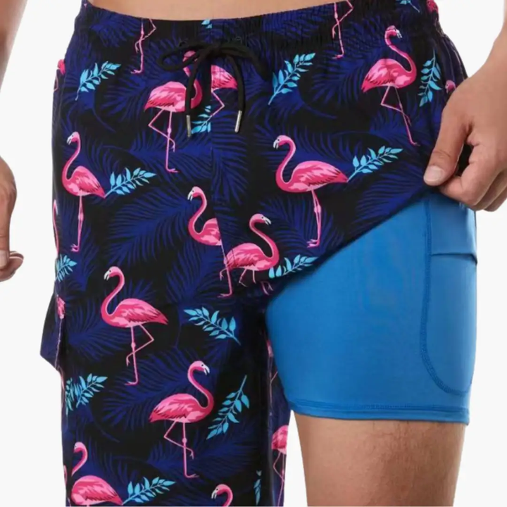 Men's tropical print swim shorts with pink flamingos and blue palm leaves over mesh lining