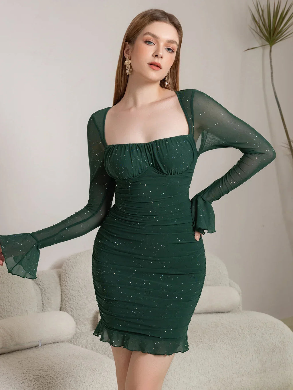 Green ruched long sleeve mini dress shown with square neckline and flared sleeve cuffs