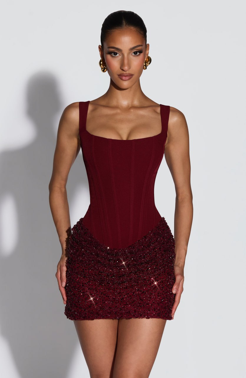 Front view of burgundy corset mini dress with square neck and glitter beaded hem