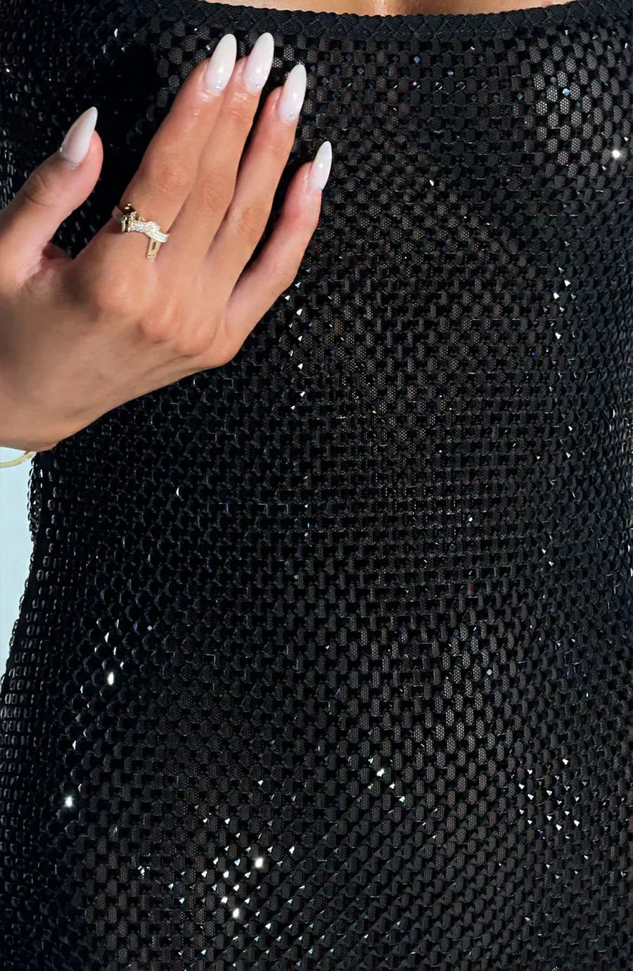 Close-up of black rhinestone mini dress showing textured sparkle and fitted cocktail style