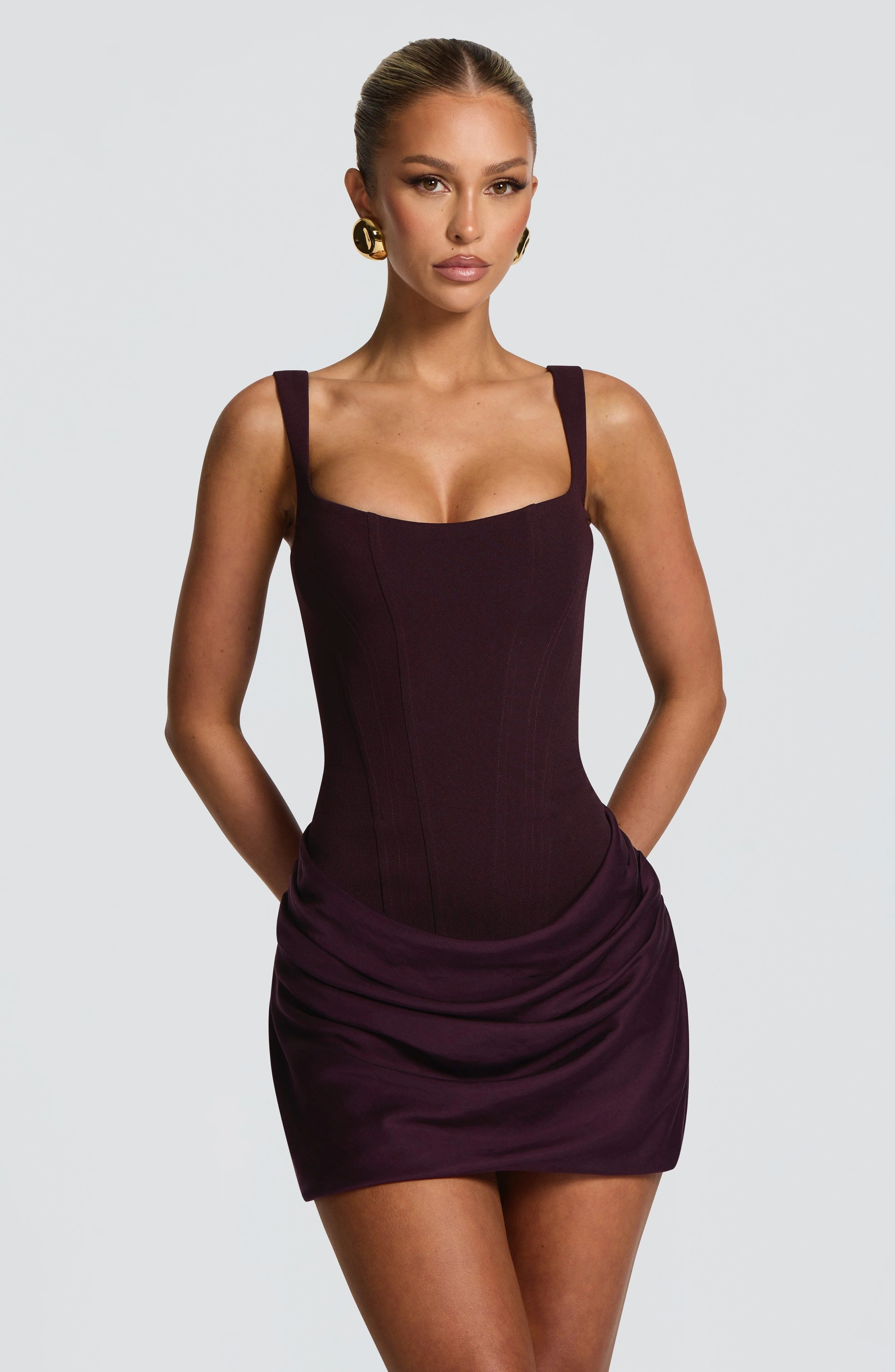 Close-up front view of plum satin mini dress with square neckline and draped mini skirt