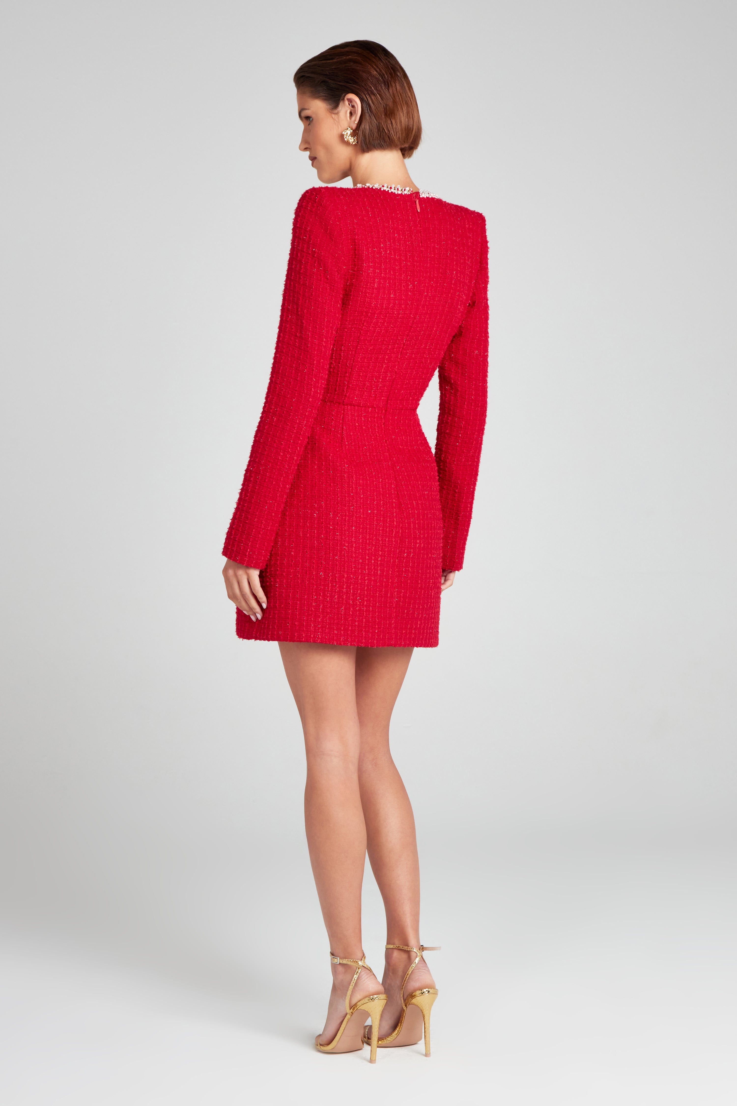 Back view of red long sleeve square neck mini dress with fitted waist and textured fabric