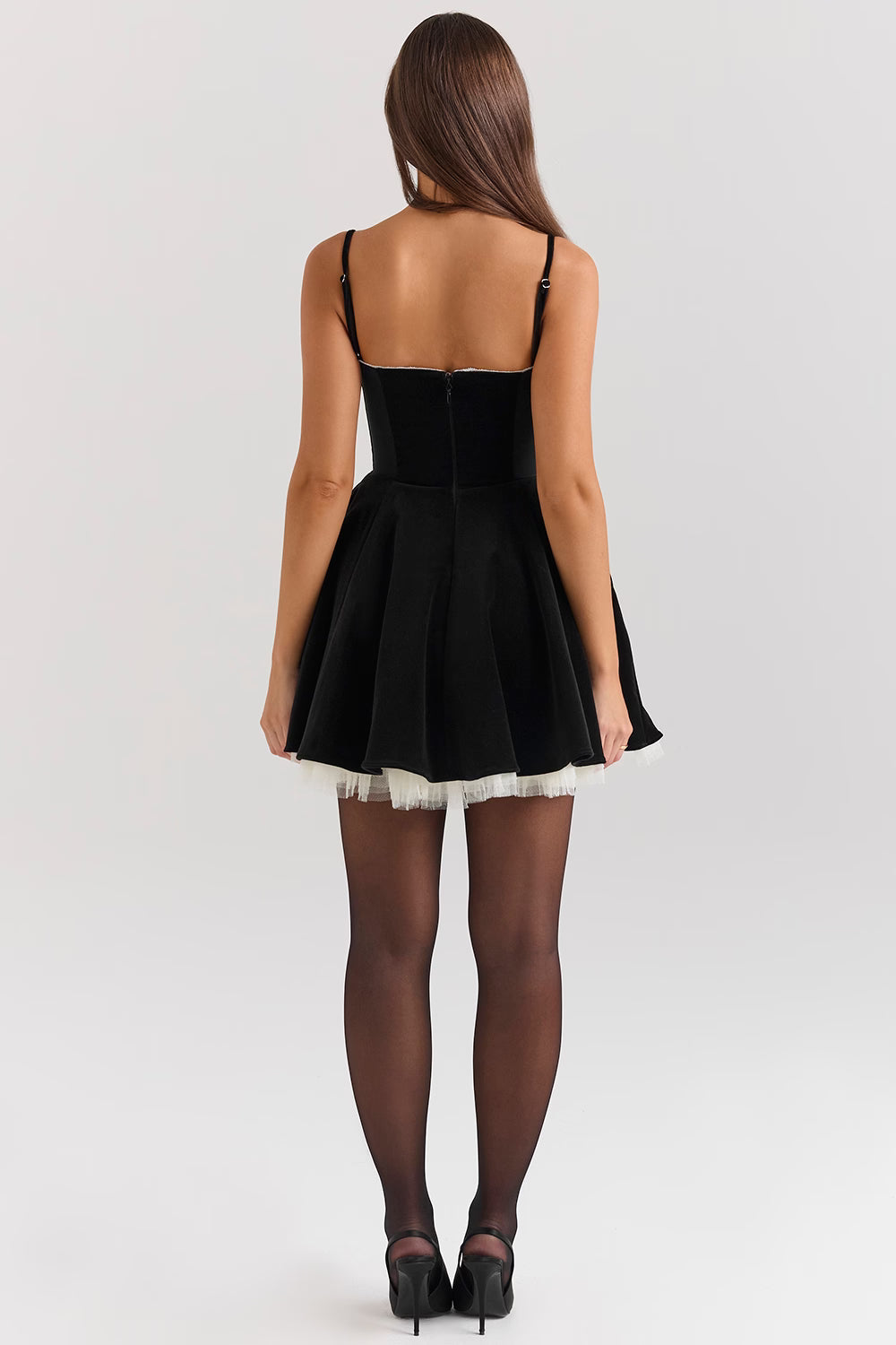 Back view black sweetheart mini skater dress with center zipper and flared skirt, studio lighting