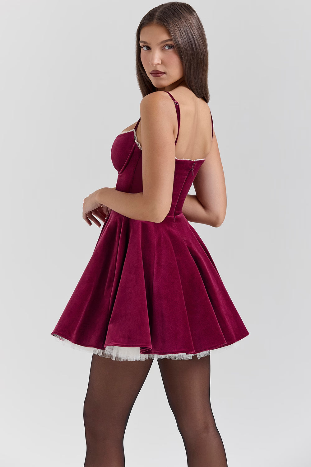 Three-quarter back view burgundy velvet mini skater dress with lace trim and layered tulle hem