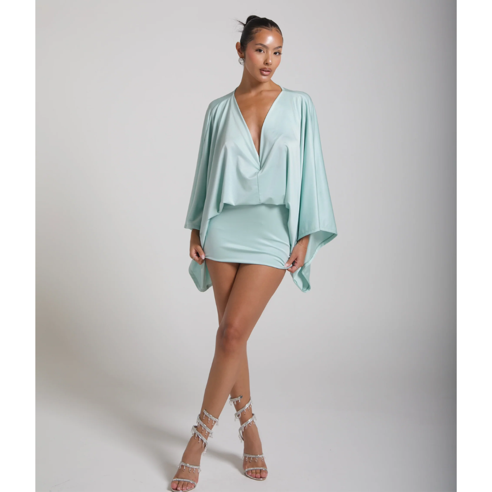 Full length view of mint green mini dress with draped sleeves and strappy heels