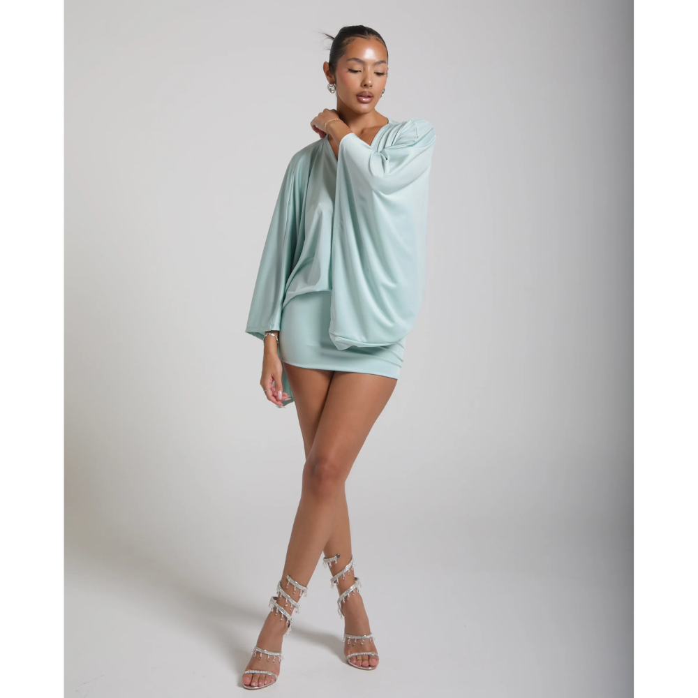 Front view of a mint v neck mini dress styled with strappy heels for cocktail wear