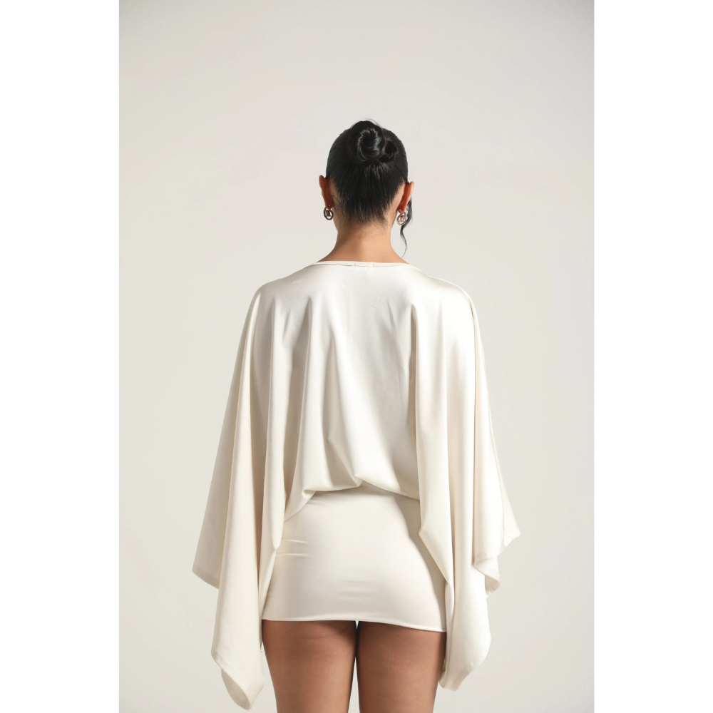 Back view of ivory mini dress with loose draped sleeves and fitted skirt