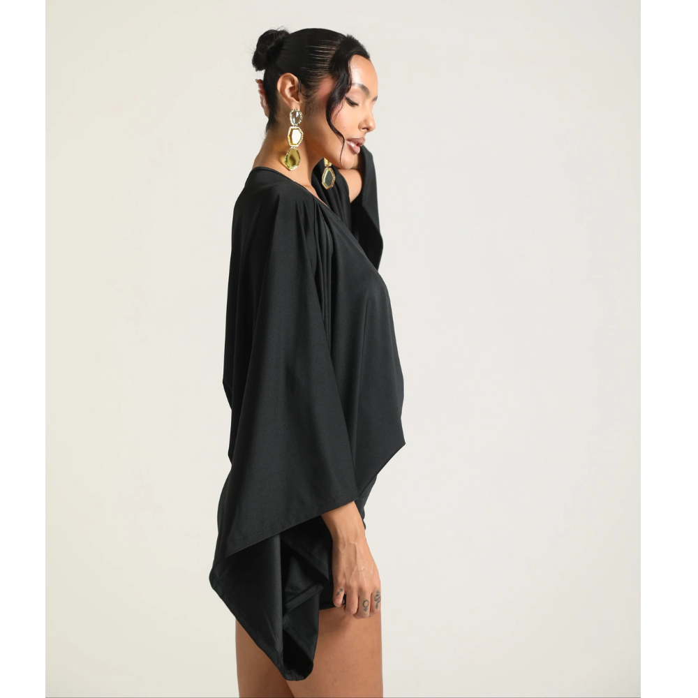 Side view of black cocktail mini dress with deep V neck and flowing sleeves