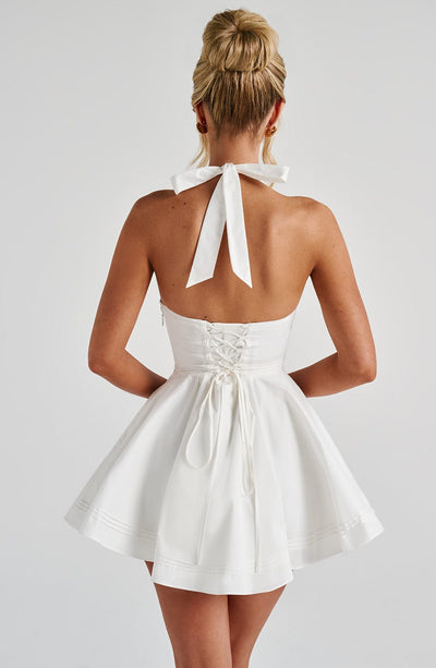Back view white halter mini dress with tie neck and lace-up corset back, fit-and-flare skirt
