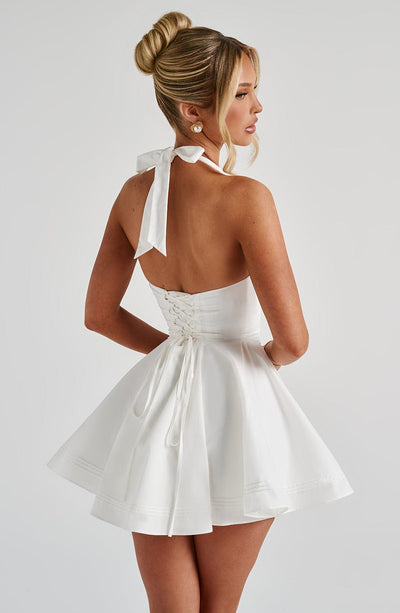 Back view white halter mini dress with lace-up corset detail and flared skirt, wedding guest dress