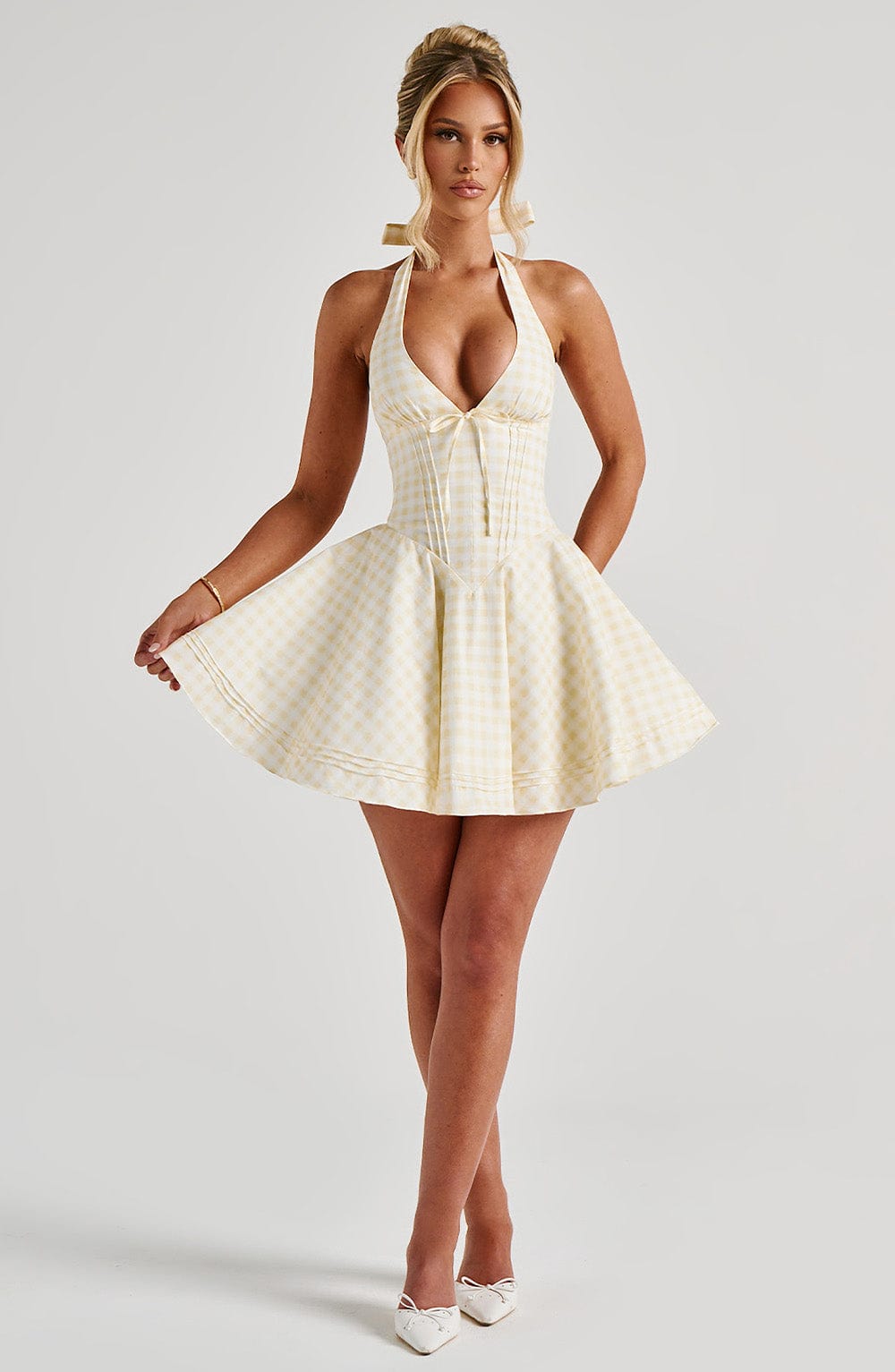 Studio full-body view of yellow gingham plunge halter mini dress with fit-and-flare skirt and flats