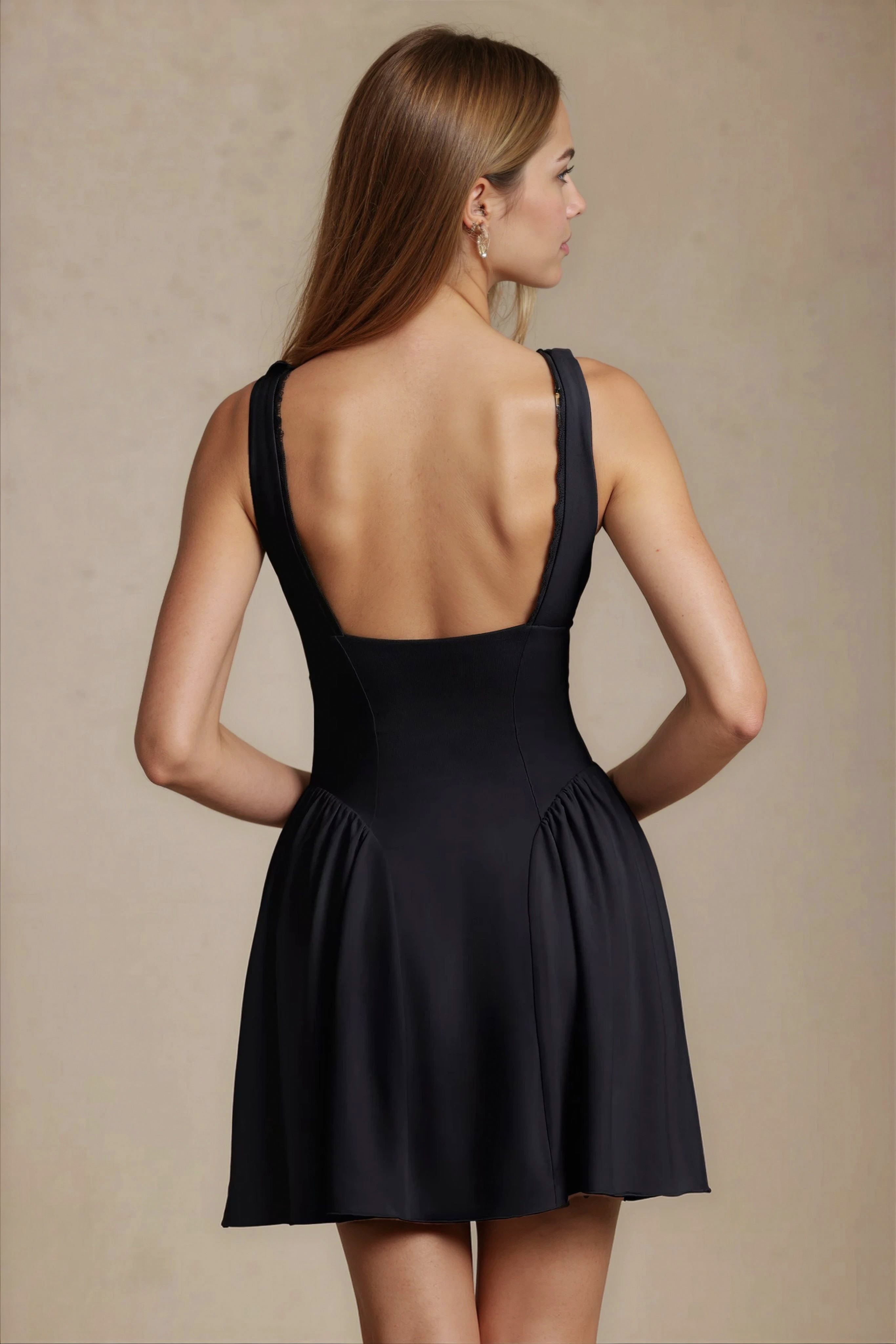 Back view of black mini dress with open low back and flared skirt