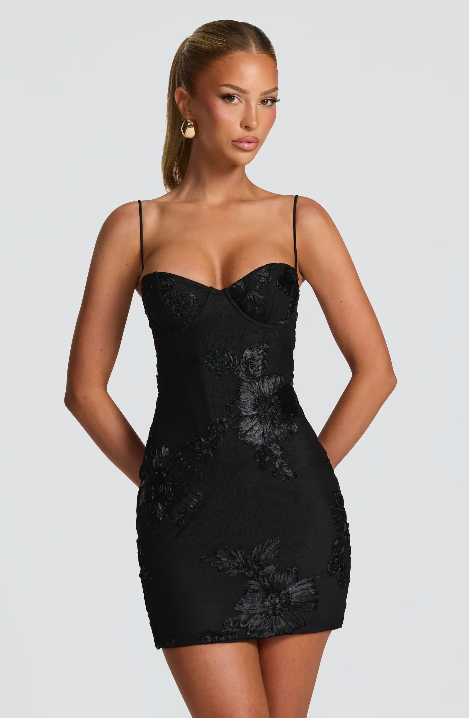 Black floral corset mini dress with thin straps and fitted wedding guest silhouette