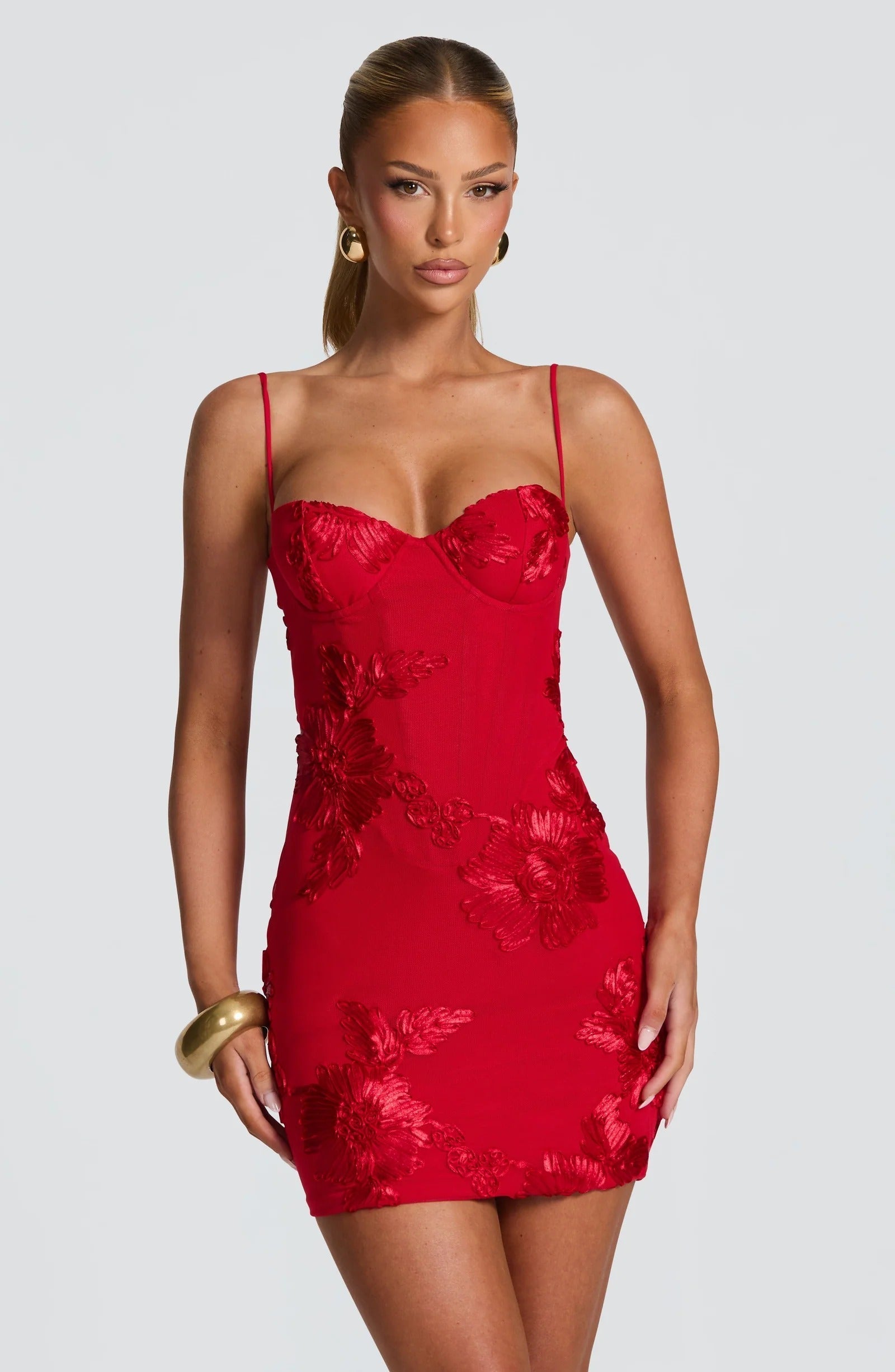 Front angled view of red wedding guest dress with floral embroidery and mini length