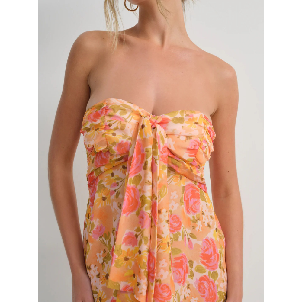 Close-up of orange floral strapless mini dress with sweetheart neckline and front tie detail