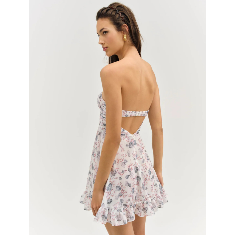 Back view of white floral strapless mini dress with open back and ruffle hem