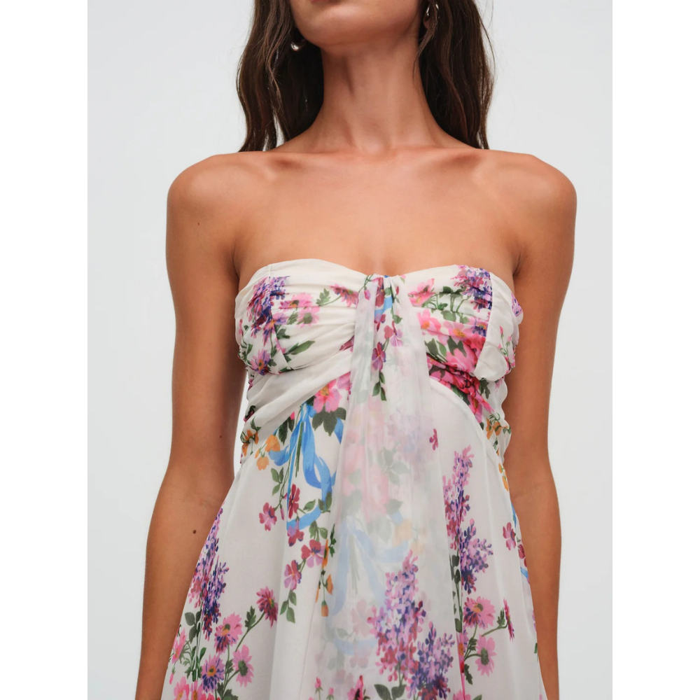 Close-up front view of a floral strapless mini dress with ruched bust and sheer overlay