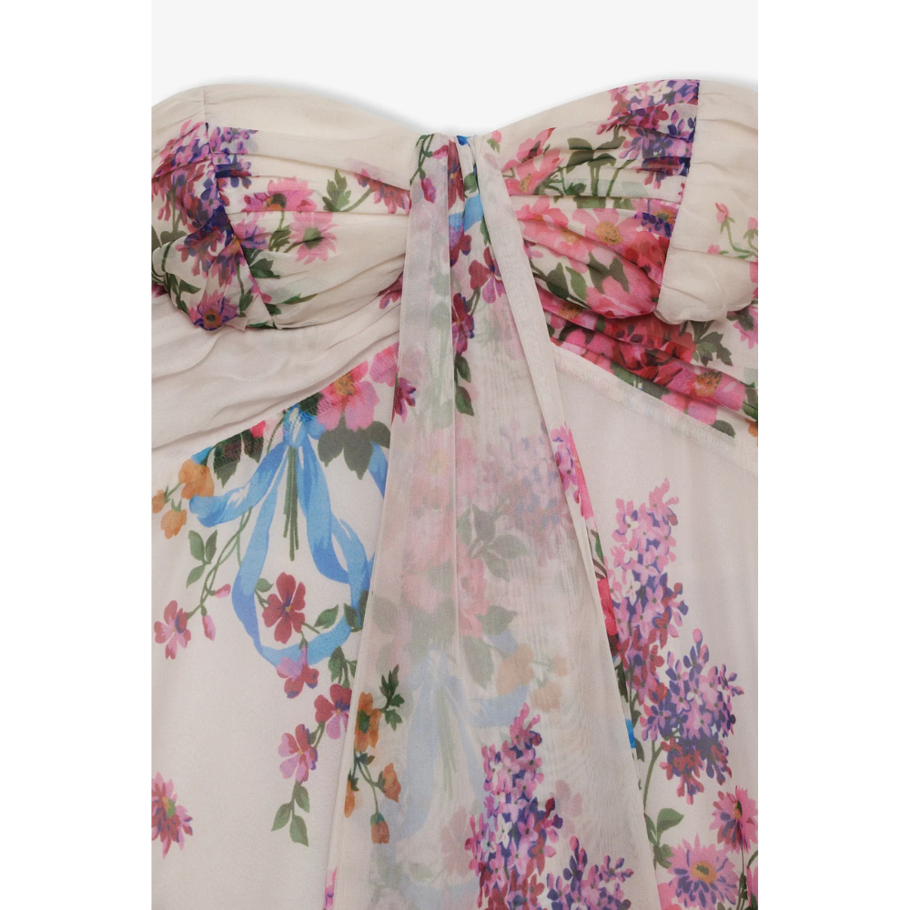 Back view of hanging floral strapless mini dress showing open back detail and ruffle hem