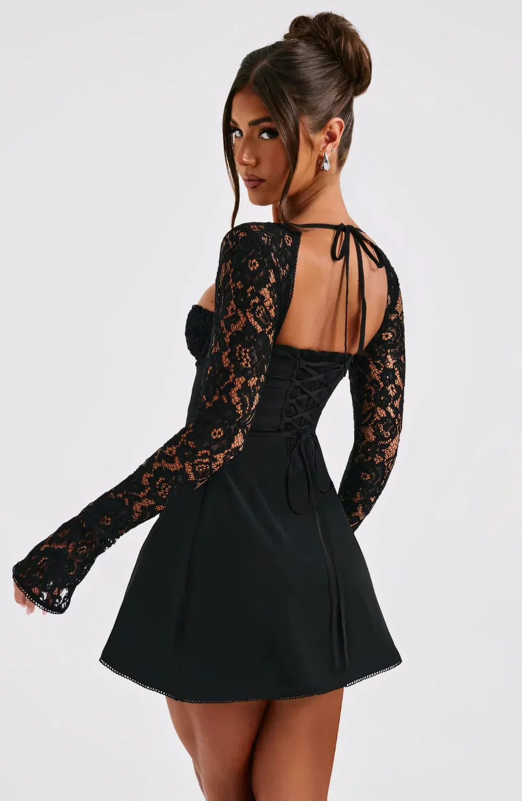Back view of black lace long sleeve mini dress with open back and tie straps