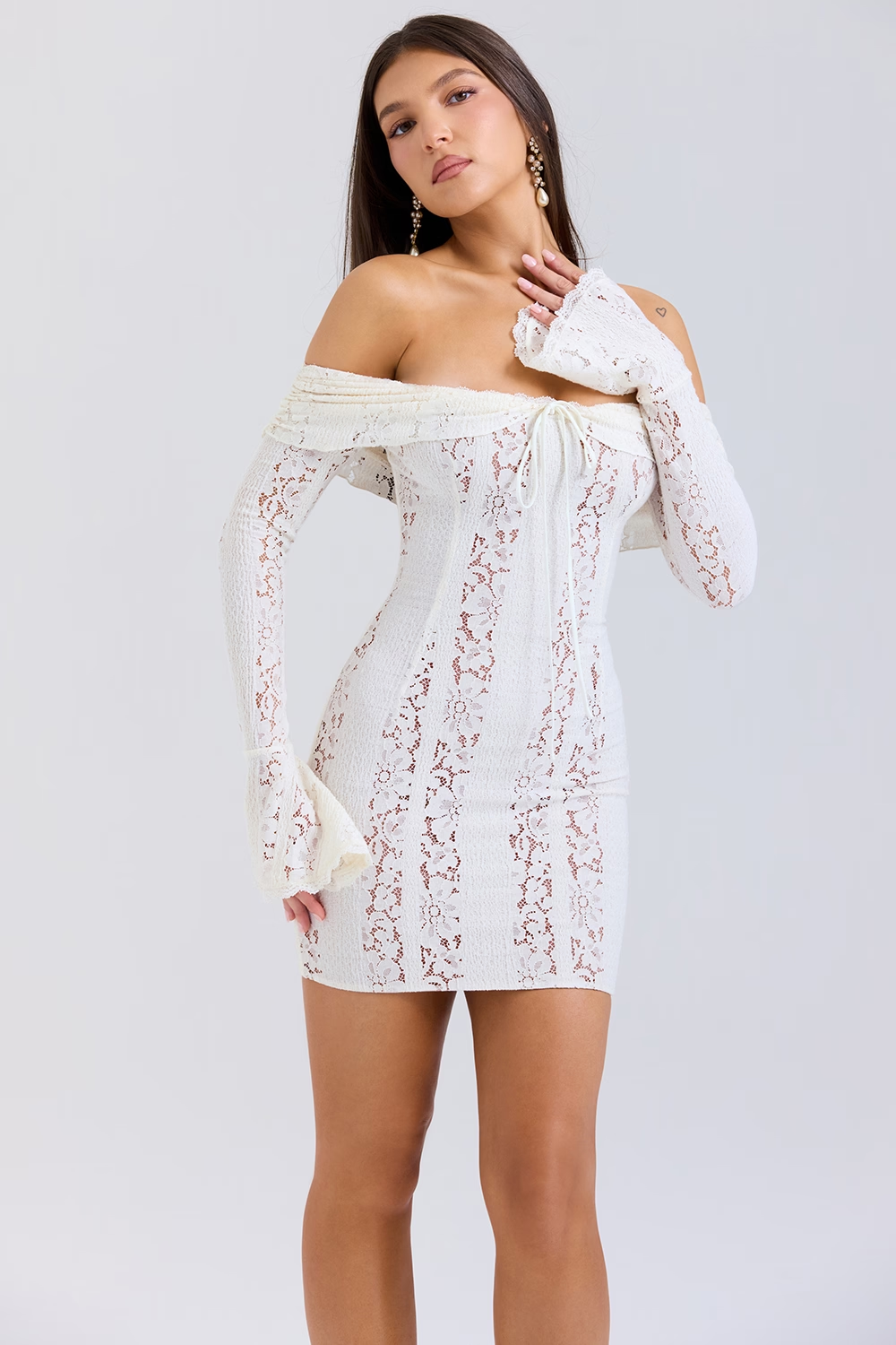 Off shoulder lace mini dress with flared sleeves and fitted silhouette in front close-up