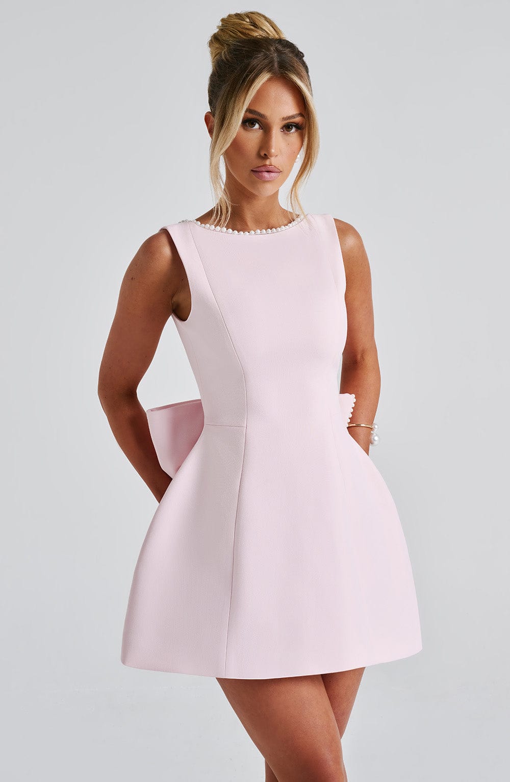 Front close view of blush pearl neckline mini A-line wedding guest dress with structured sleeveless bodice