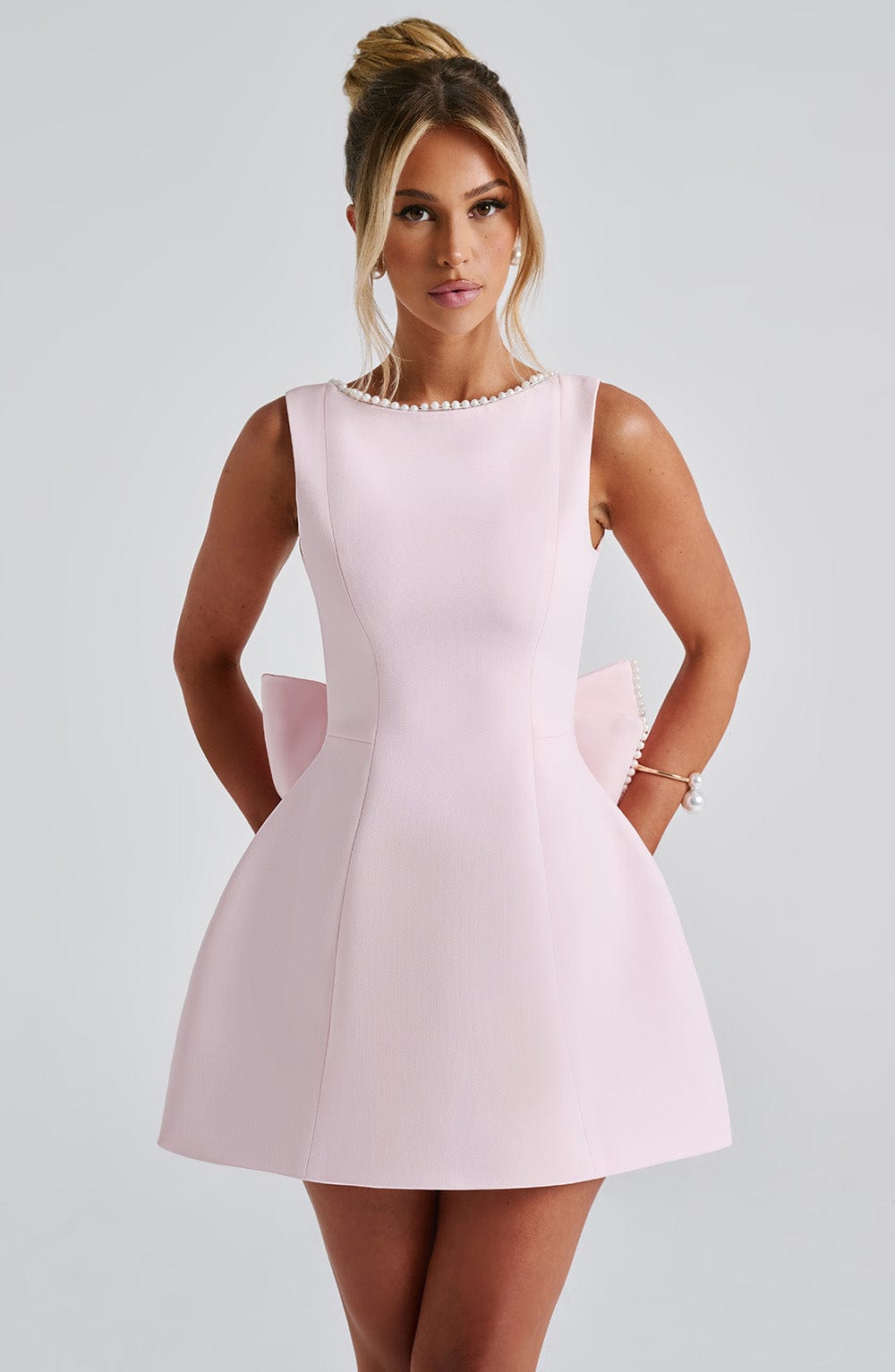 Blush pink pearl trim mini A-line wedding guest dress, sleeveless front view with sculpted skirt