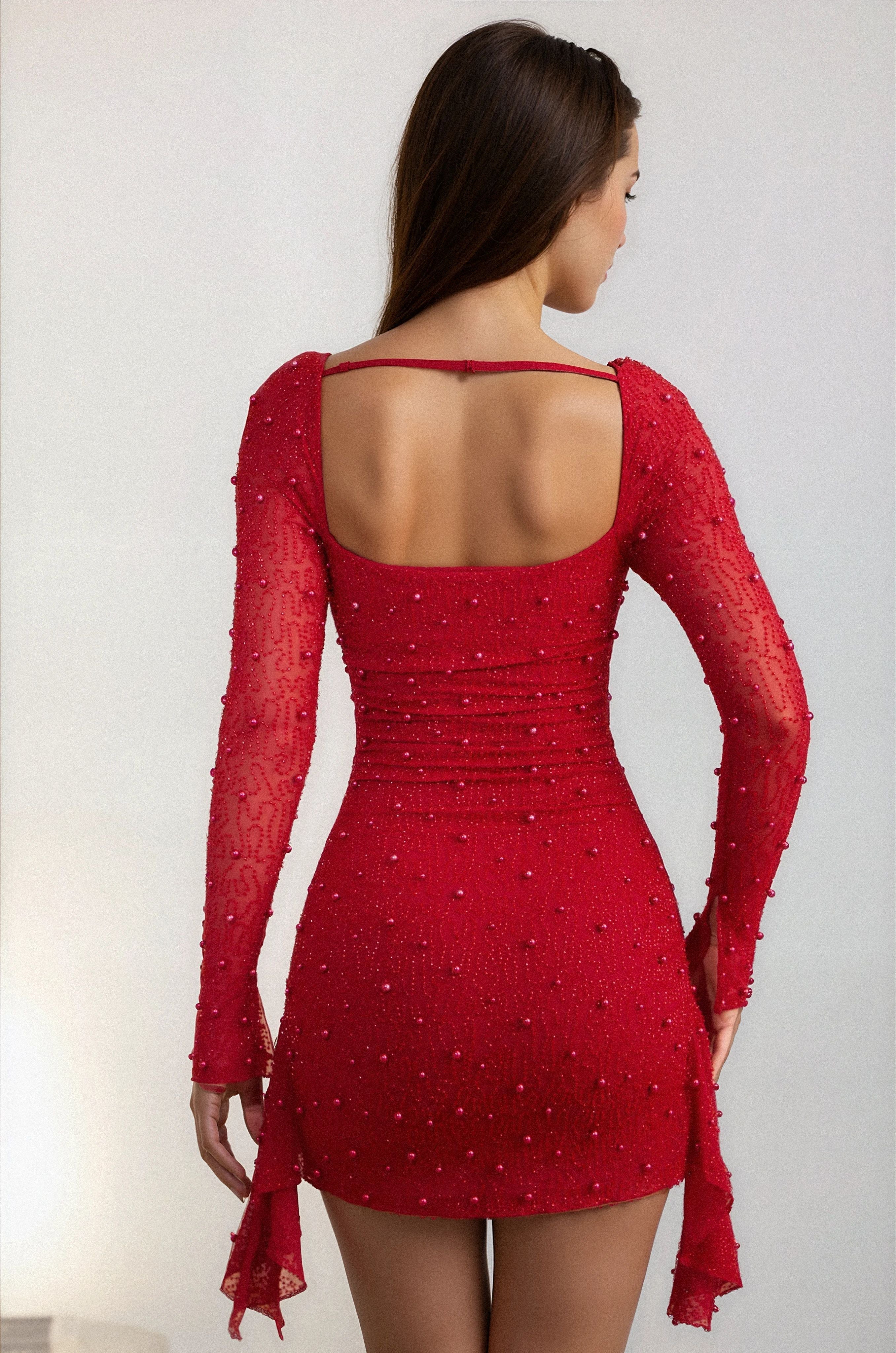 Side view of red wedding guest mini dress with ruched fit and beaded sheer sleeves