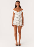 Front full-length view of white polka dot off shoulder mini dress with bubble skirt, wedding guest dress