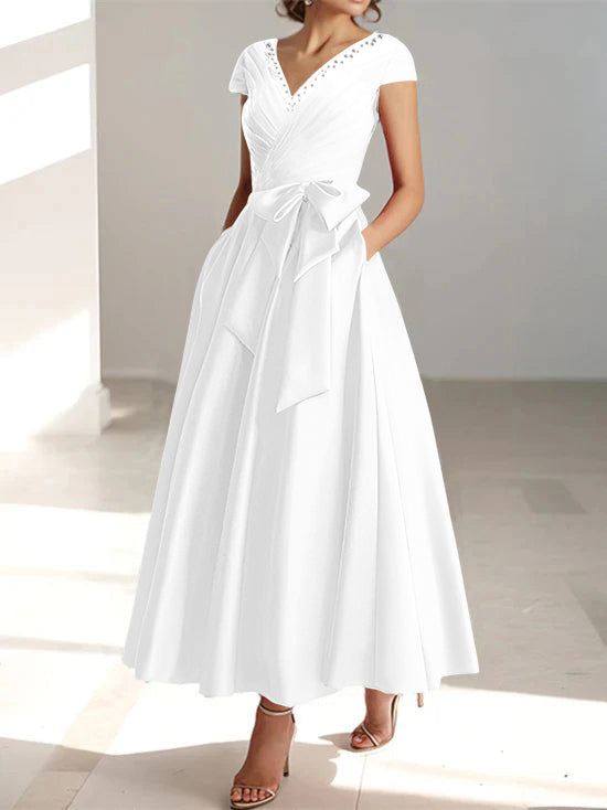 White a-line midi dress with v-neck, short sleeves, and functional pockets