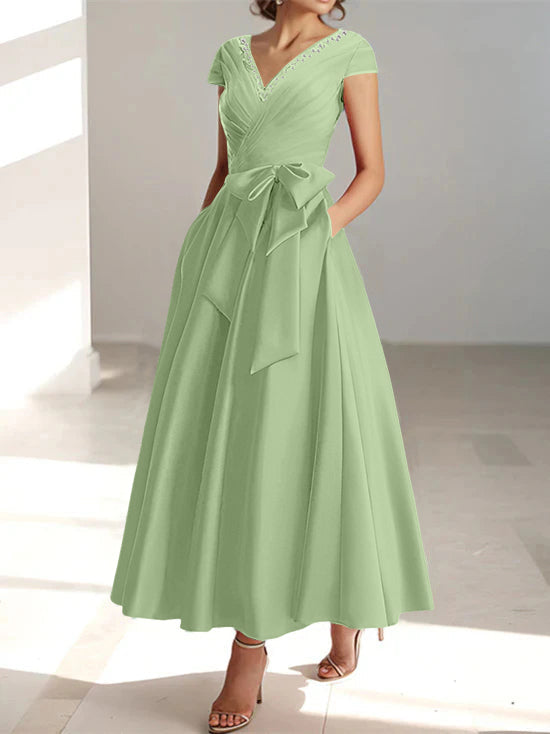 Mint green a-line midi dress with v-neck, short sleeves, and functional pockets