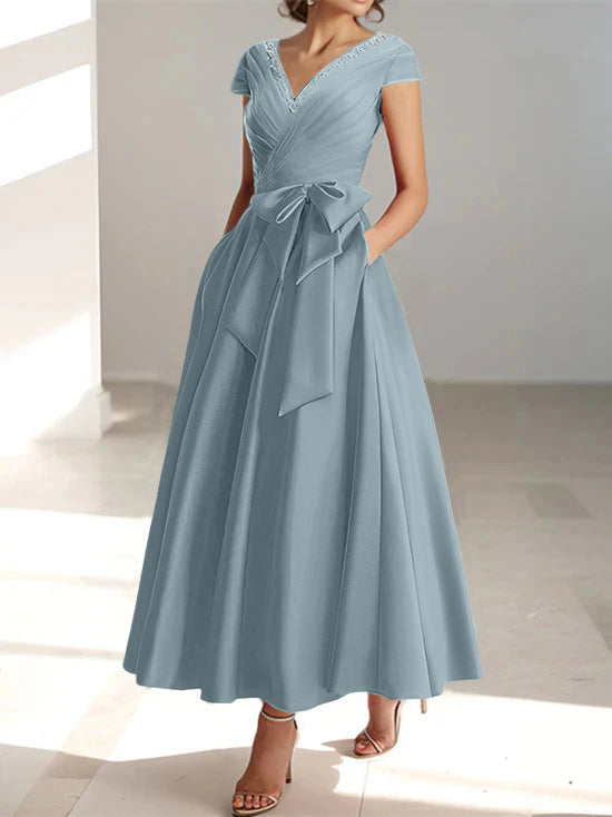 Dusty blue A-line midi dress with V-neck, short sleeves, and bow detail