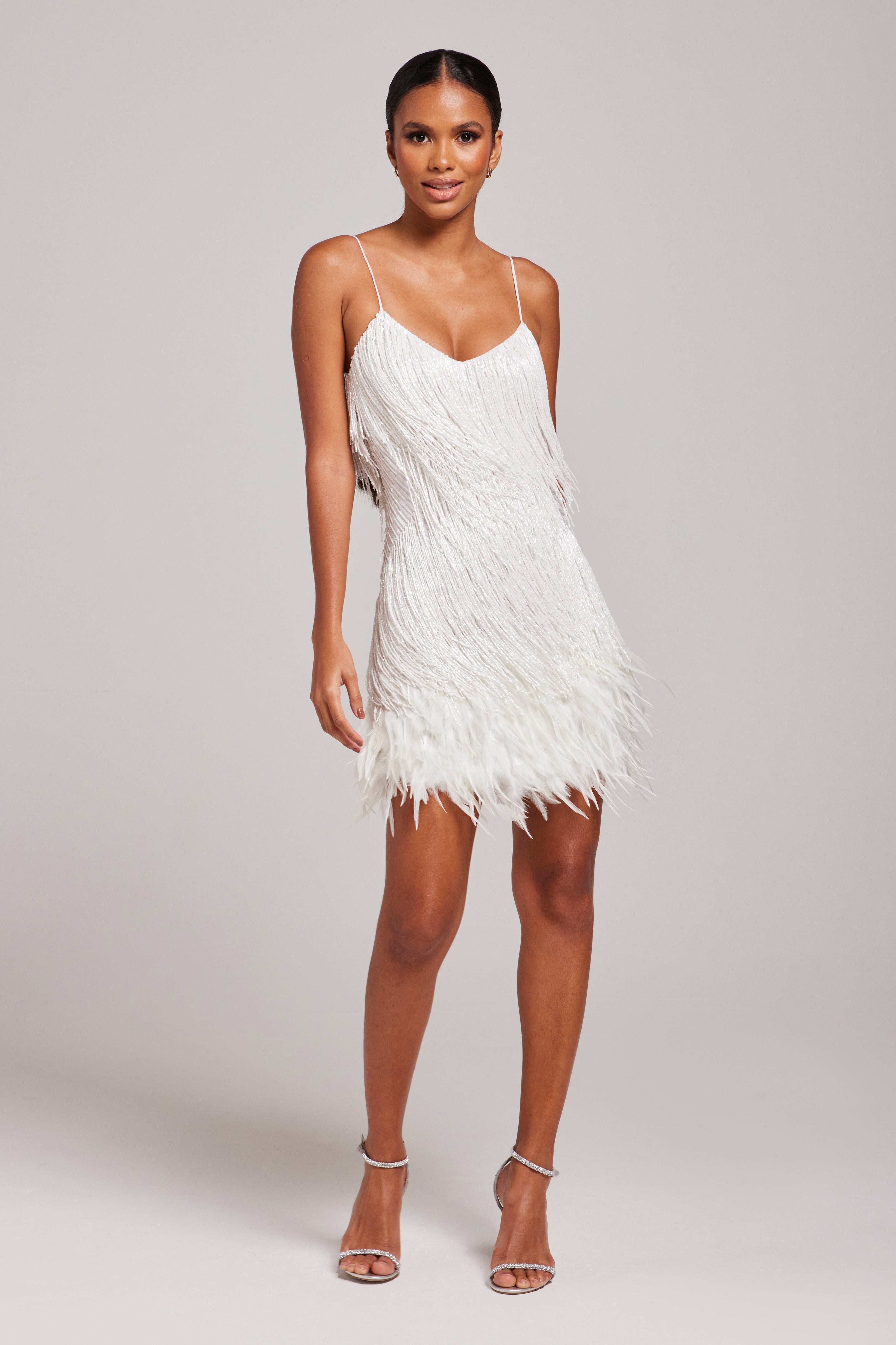 Front view of white fringe mini dress with V-neckline and layered feather trim
